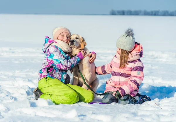 Дівчата з собакою на зимовій прогулянці — стокове фото