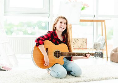 Gitarla gülümseyen genç kız