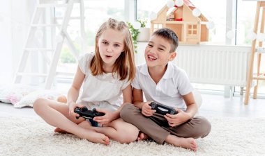 Küçük çocuk ve kız video oyunu oynuyorlar.
