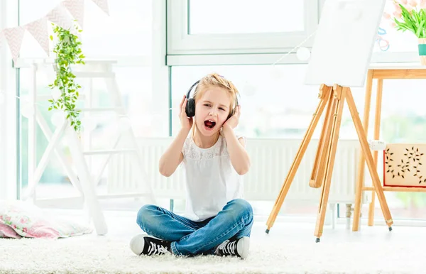 Nettes kleines Mädchen in Kopfhörern singt — Stockfoto