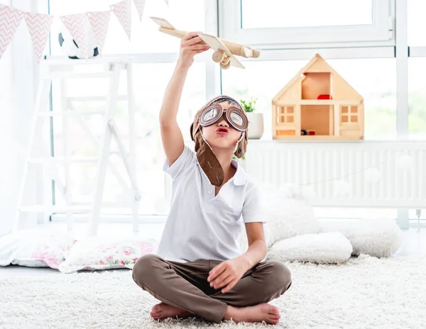 Söt liten pojke flyger trä plan — Stockfoto