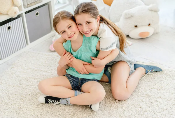 Υπέροχες αδελφές αγκαλιάζονται στο playroom — Φωτογραφία Αρχείου