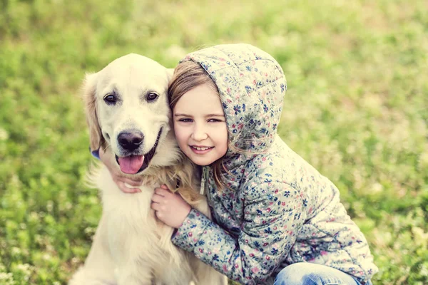 Gelukkig klein meisje knuffelen schattig hond — Stockfoto