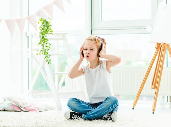 Søt liten jente med hodetelefoner som synger – stockfoto