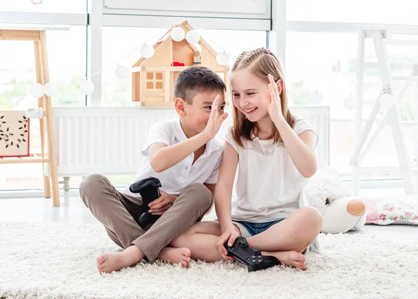 Kids giving high five while video gaming — Stock Photo, Image