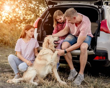 Köpekli aile açık arabanın yanında.