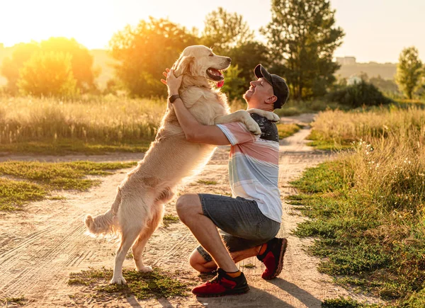 Golden retriever insanın yanında duruyor. — Stok fotoğraf