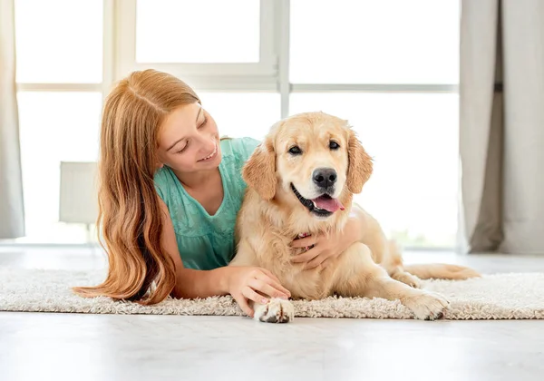 Chica joven acostada con golden retriever —  Fotos de Stock