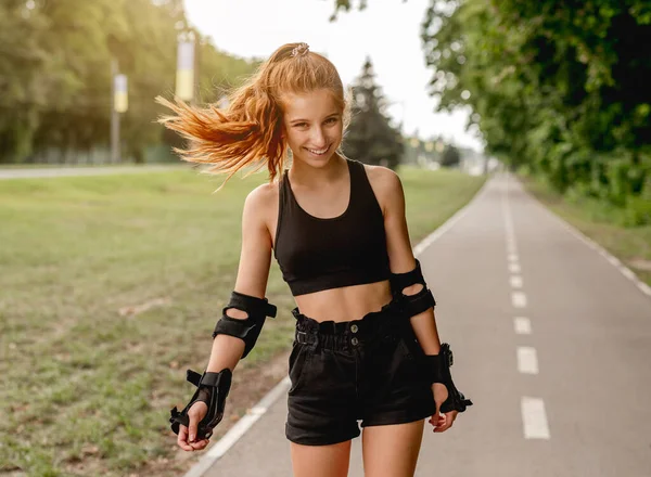Ragazza adolescente in abbigliamento sportivo pattinaggio a rotelle — Foto Stock