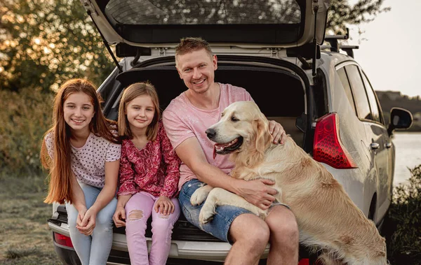 Rodzina z psem obok otwartego samochodu — Zdjęcie stockowe