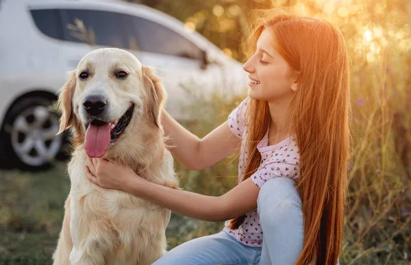 Retrato de menina adolescente petting golden retriever — Fotografia de Stock