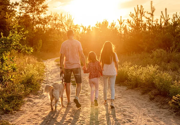 Döttrar med far och hund i naturen — Stockfoto