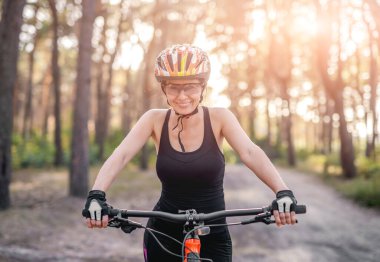 Ormanda bisiklet süren bir kadın