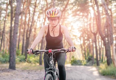 Ormanda bisiklet süren bir kadın