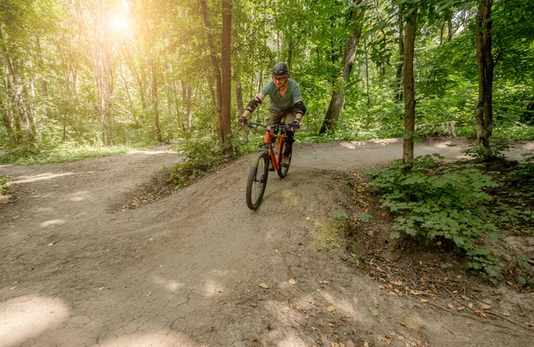 Homem andar de bicicleta na estrada da floresta — Fotografia de Stock