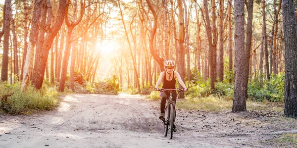 Woman riding bicycle in forest — Stock Photo, Image