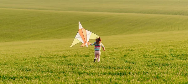 Bambina che tiene aquilone al tramonto — Foto Stock