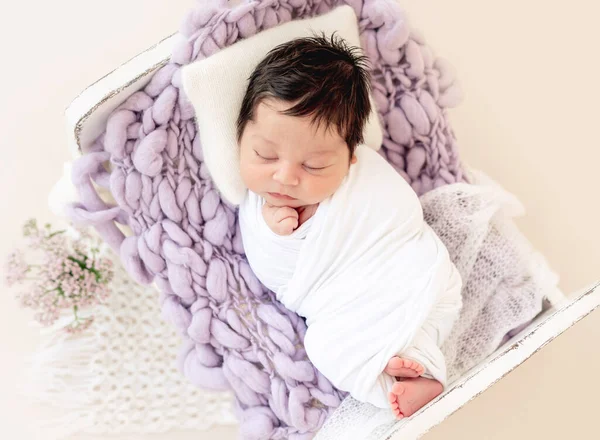 Vtipné novorozeně odpočívající na malé posteli — Stock fotografie