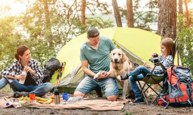 Ormanda piknik yaparken köpekli bir aile