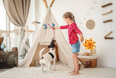 Küçük kız tilki teriyeriyle oynuyor.