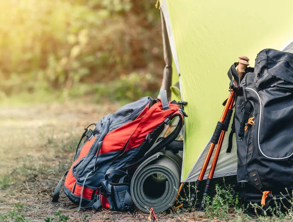 Backpacks, karemat and trekking sticks near tent — Stock Photo, Image