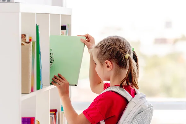 Chica de la escuela en máscara protectora en la biblioteca —  Fotos de Stock