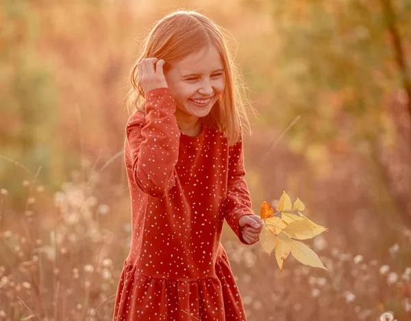 Lycklig liten flicka med gula blad — Stockfoto