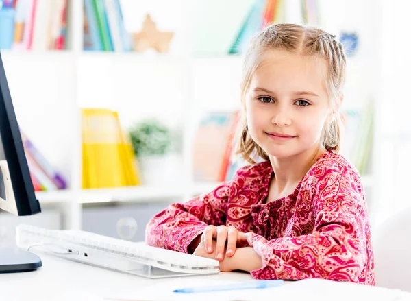 Bilgisayarın önünde oturan küçük kız. — Stok fotoğraf