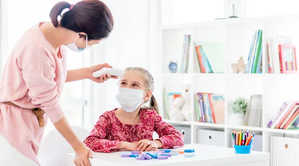 Lehrer misst Temperatur eines Schülers mit Thermometer — Stockfoto