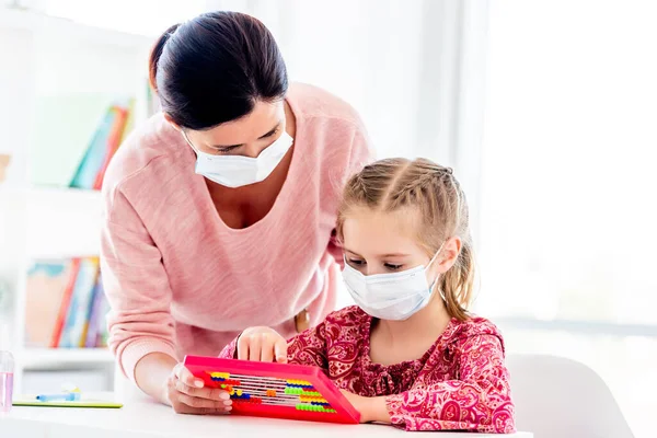 Lehrerin und Schülerin in Schutzmasken — Stockfoto