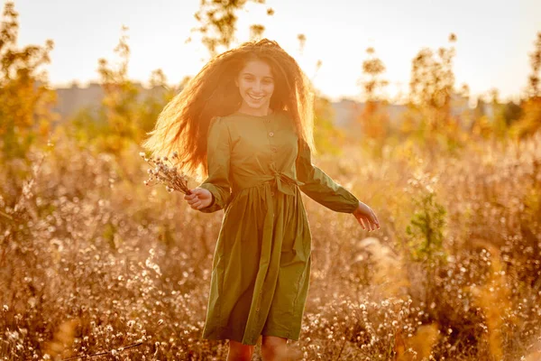 Ευτυχισμένο νεαρό κορίτσι που κρατάει φθινοπωρινό λουλούδι — Φωτογραφία Αρχείου