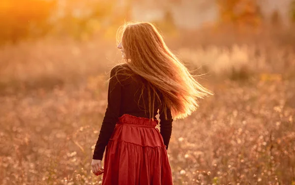 Young girl standing on autumn field — Stock Photo, Image