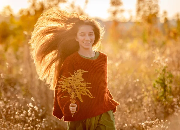 Herbstblumen in den Händen junger Mädchen — Stockfoto
