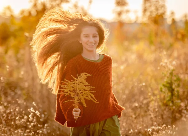 Autumn flowers in young girl hands — Stock Photo, Image