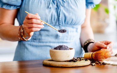 Mavi kibrit çayı kaseye dönüştürmek için Kadın Çayı Ölçüyor