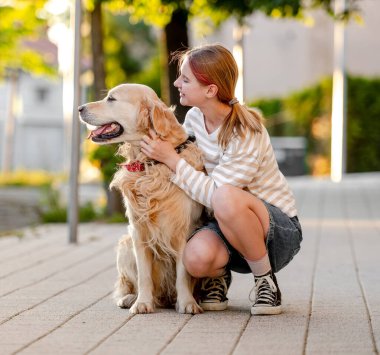 Mutlu kız dışarıda Golden Retriever Dog 'a sarılıyor