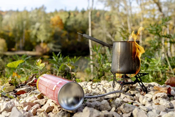 Portable tourist gas stove with a gray kettle on a background of nature in the mountains. Camping kitchen and tea. Unsafe gas stpve. — Stock Photo, Image