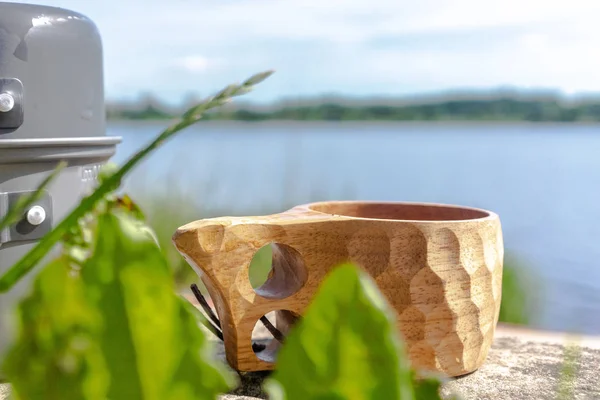 Taza de madera con café para llevar en el fondo del río . — Foto de Stock