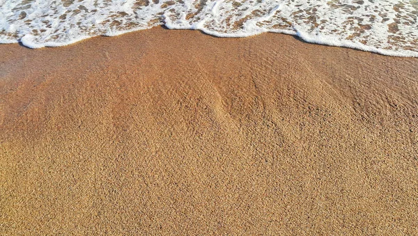 サンディ ビーチ背景と白い泡の海の波 クローズ アップ自然な風合いの — ストック写真