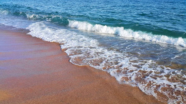 海岸の砂の上に白い泡と海の波 自然なクローズアップの背景 — ストック写真