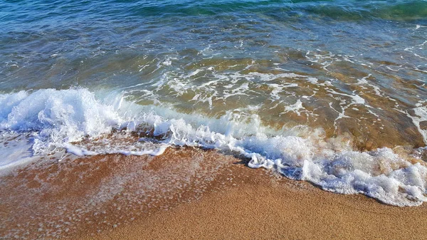Sea water with white foam on the coastal sand — Stock Photo, Image