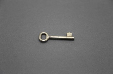 Gri kağıt arka plan üzerinde eski metal anahtar