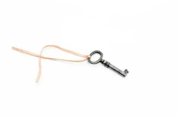 Vintage silver key with pink ribbon on white background — Stock Photo, Image