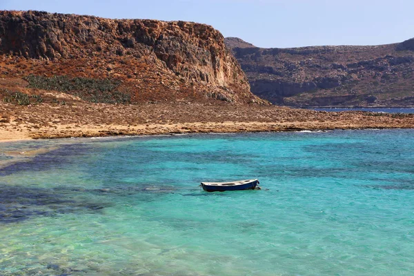 Sjøutsikt med åpent turkis og tom båt på Kreta – stockfoto