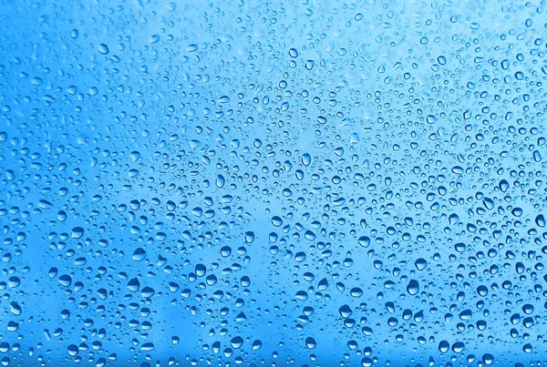 Gotas de agua sobre vidrio, textura azul natural —  Fotos de Stock