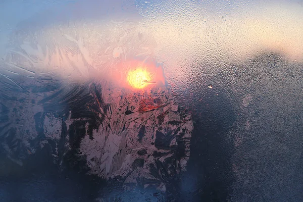 Eismuster und Wassertropfen auf Glas an einem sonnigen Wintermorgen — Stockfoto
