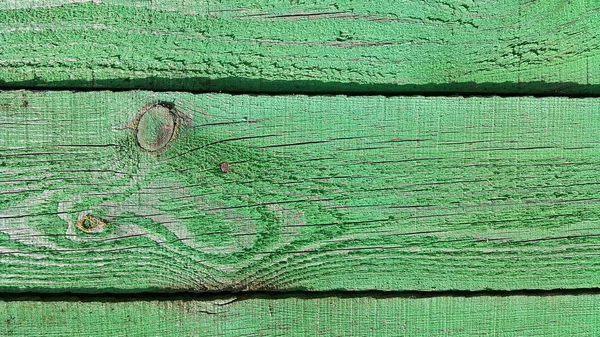 Texture of weathered wooden green painted fence