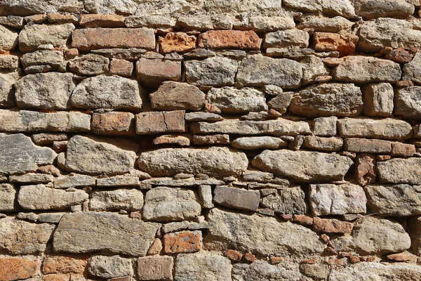 用阳光照射的石头和砖制成的古老墙壁的结构 — 图库照片