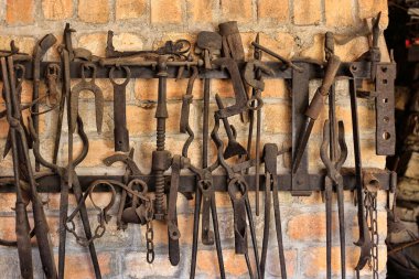 Demirci dükkanında askıda asılı duran antika iş aletlerinin yakın çekimi