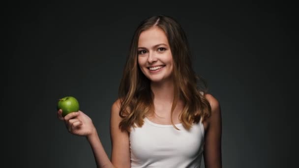 Portrait de jeune belle femme caucasienne avec pomme. Sourire à la caméra . — Video